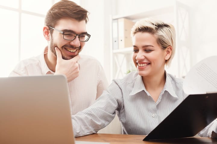 Two young employees happy thanks to their salary benefits